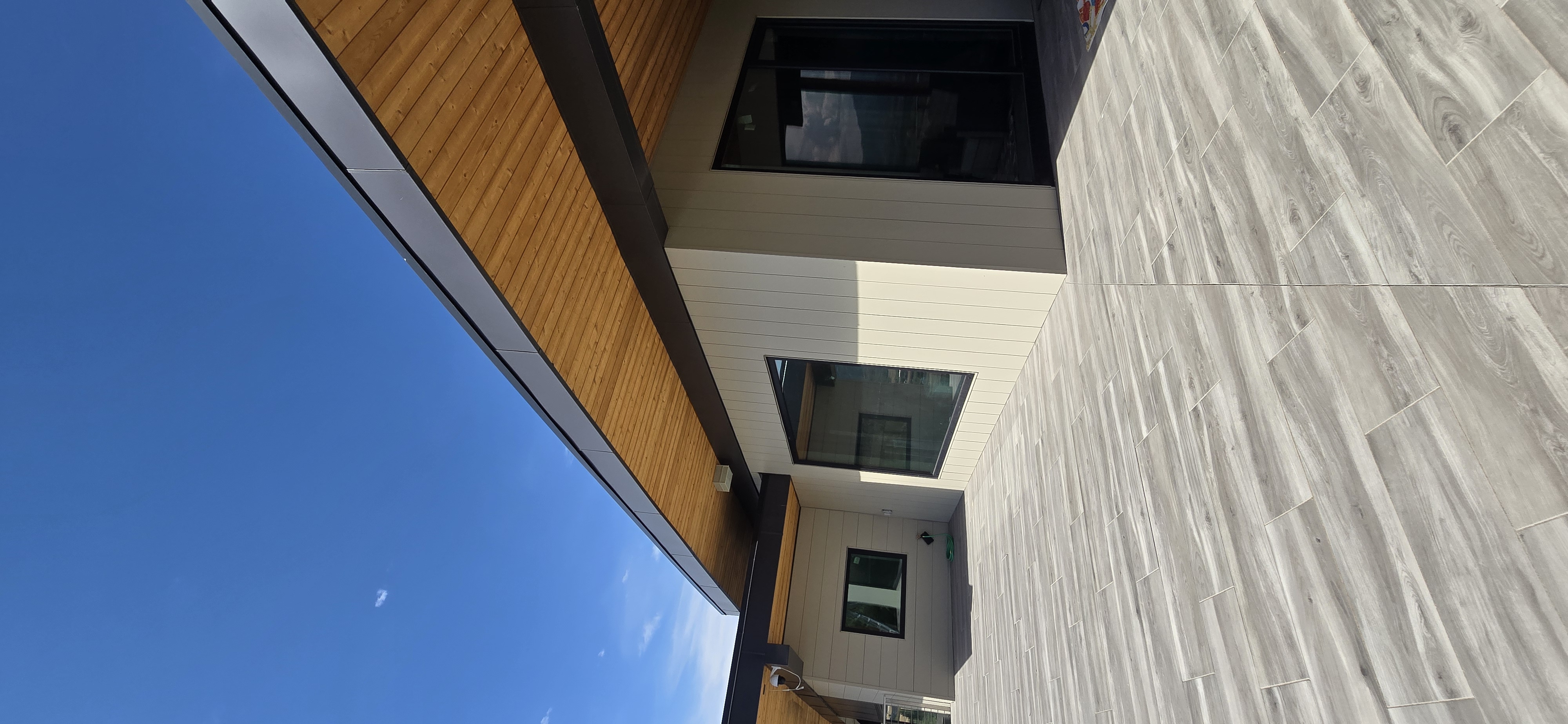 Modern home exterior with wood soffit and tile patio